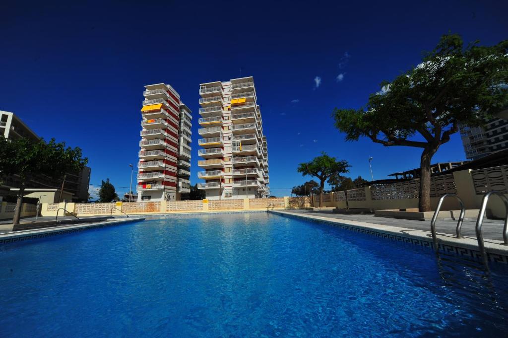 a swimming pool in front of two tall buildings at Apartamentos Estoril I - II Orangecosta in Benicàssim