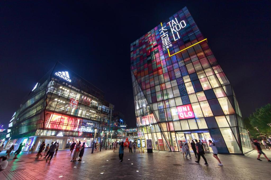 a group of people walking in front of two tall buildings at Beijing Sanlitun Shimao International Serviced Apartments in Beijing