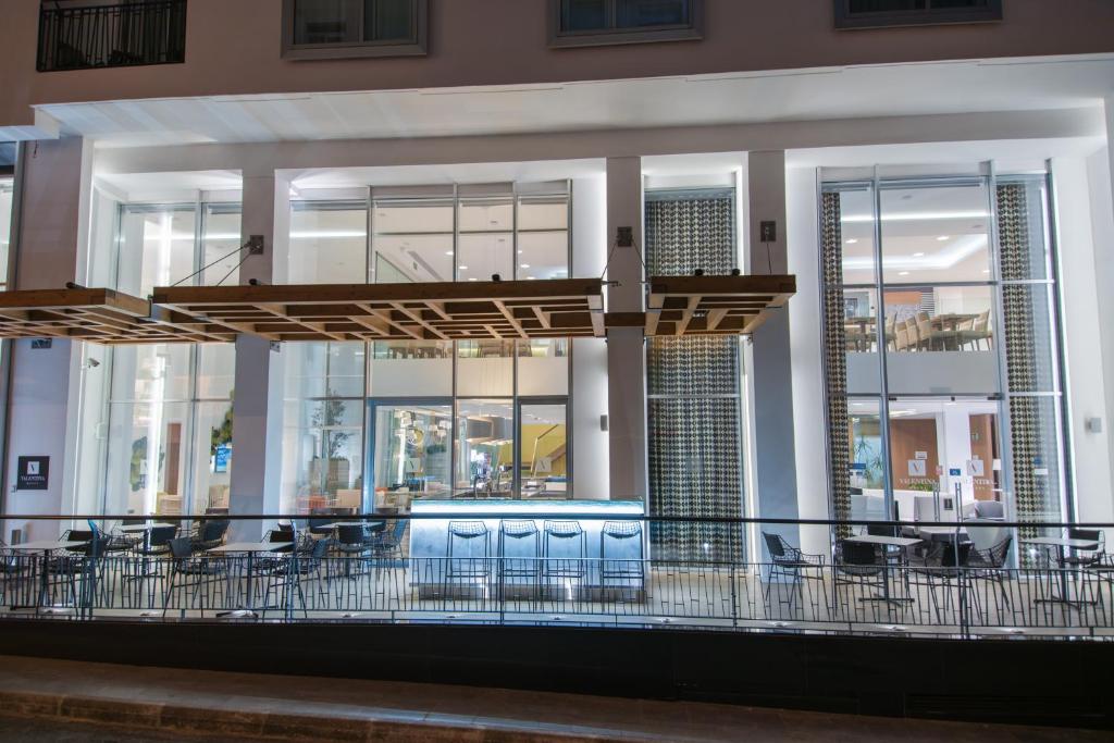 a building with a balcony with chairs and tables at Hotel Valentina in St. Julianʼs