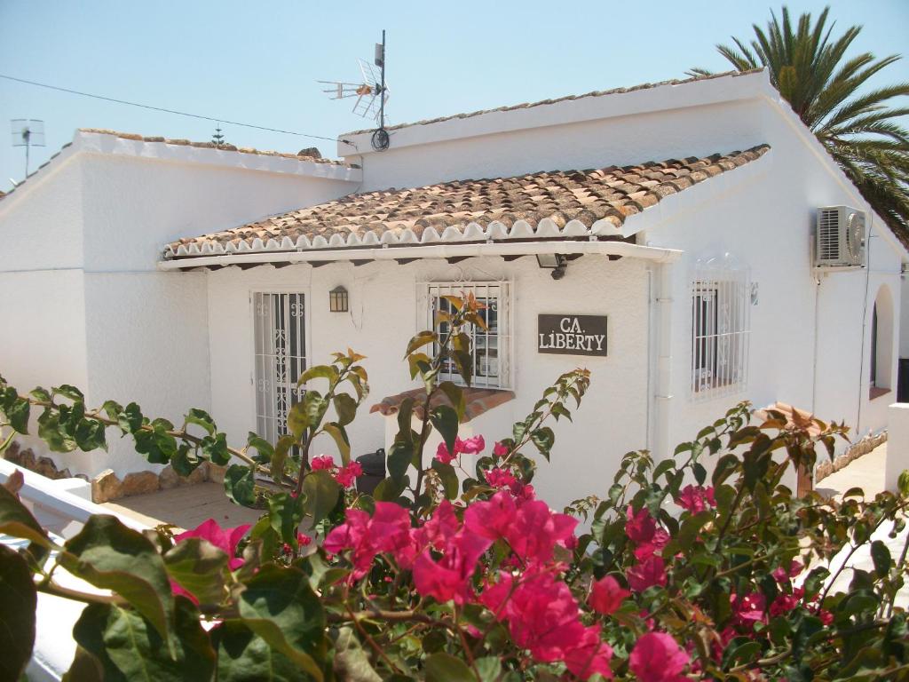a white house with pink flowers in front of it at Ca Liberty in Moraira