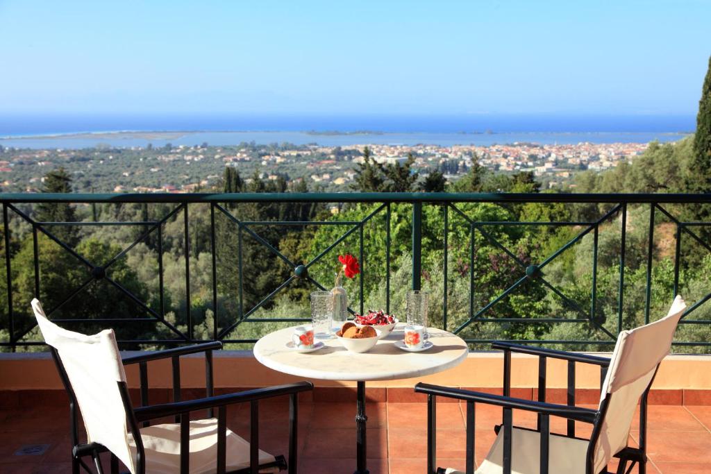 einen Tisch und Stühle auf einem Balkon mit Aussicht in der Unterkunft Orizzonte Apartments Lefkada in Lefkada Town