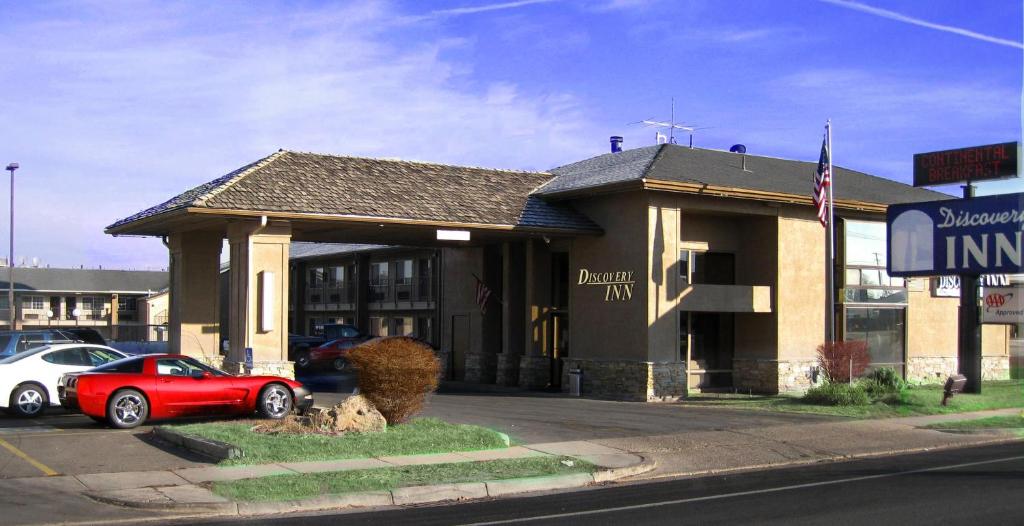 a building with a red car parked in front of it at Discovery Inn in Midvale