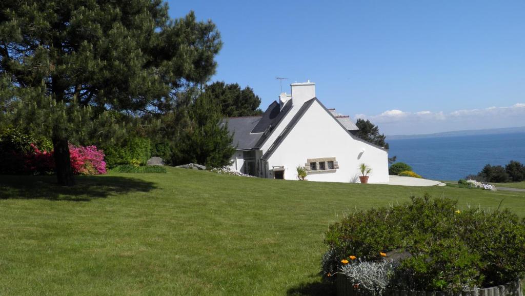 ein weißes Haus auf einem Grashügel in der Unterkunft Kichen Ar Mor in Poullan-sur-Mer