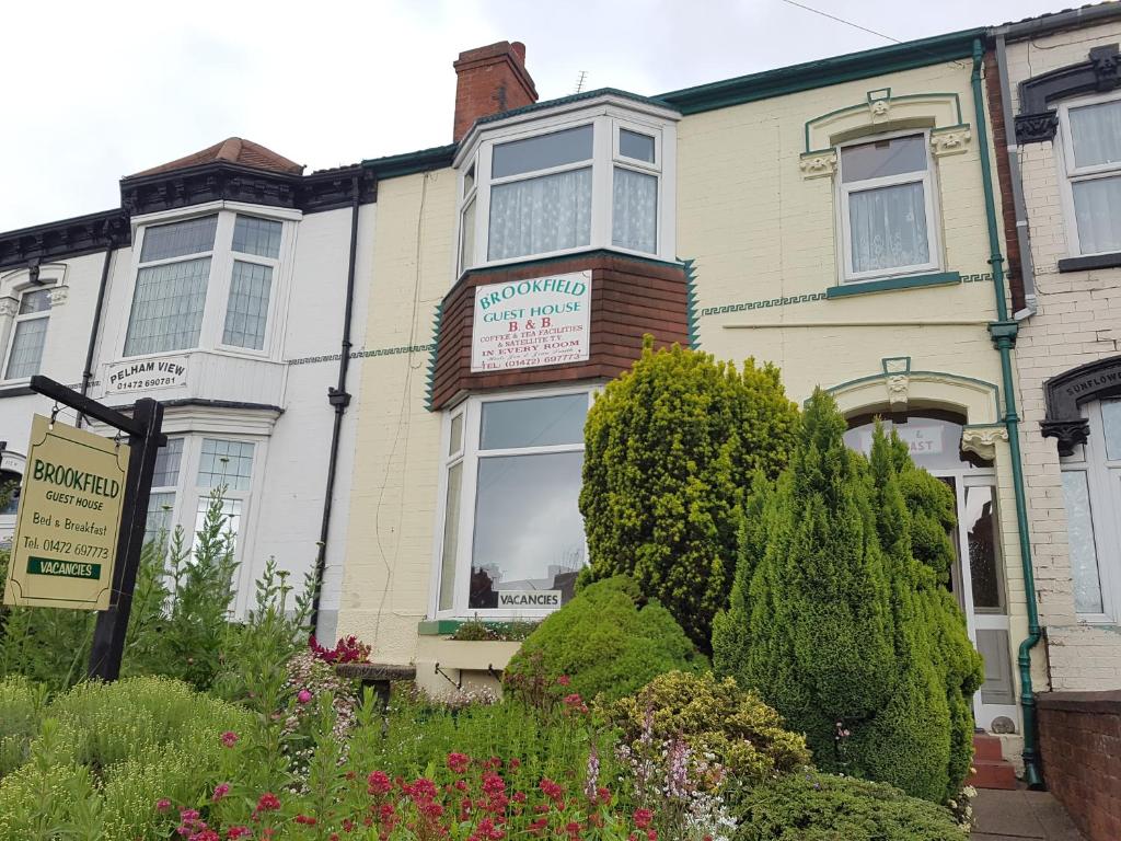 Una casa con un cartel en la ventana. en Brookfield Guesthouse en Cleethorpes