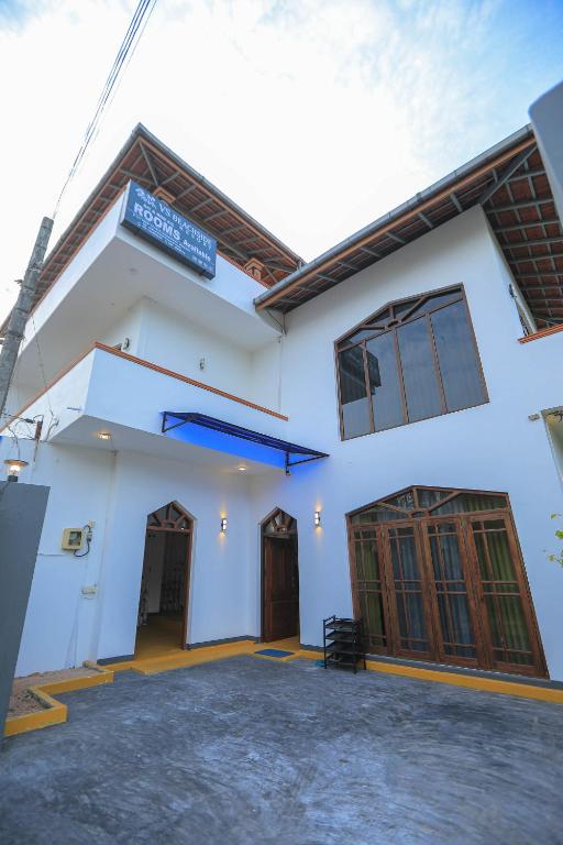 尼甘布VS BeachSide Resort的白色的建筑,有两扇门,上面有标志