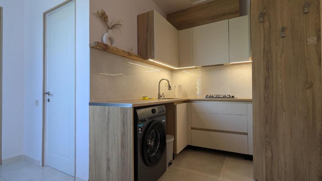 a kitchen with a washing machine in a kitchen at Cosy At Home in K'obulet'i