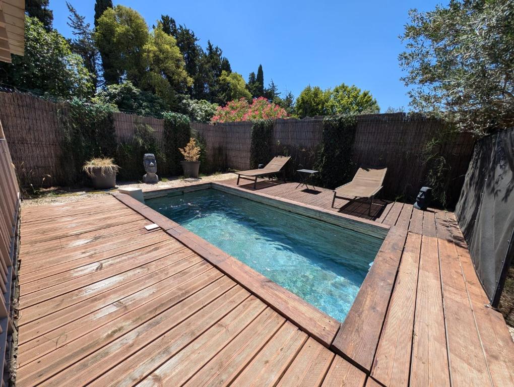 une piscine avec une terrasse en bois et une visière en bois dans l'établissement Impression du Sud Gîte 2, à Saint-Rémy-de-Provence