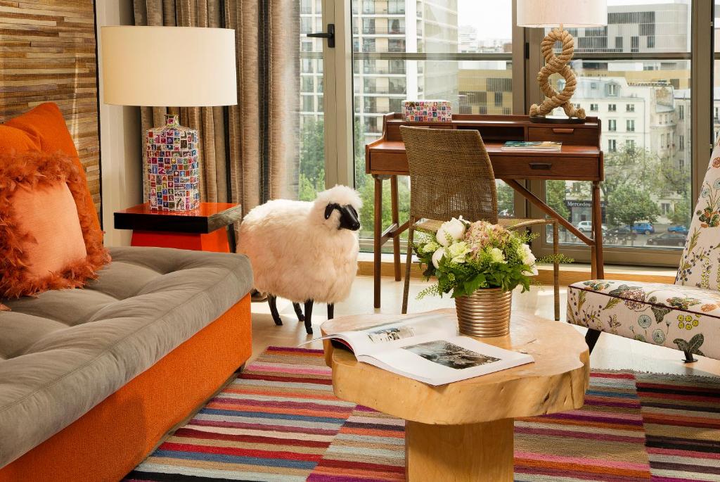 a living room with a couch and a table at Goralska Résidences Hôtel Paris Bastille in Paris