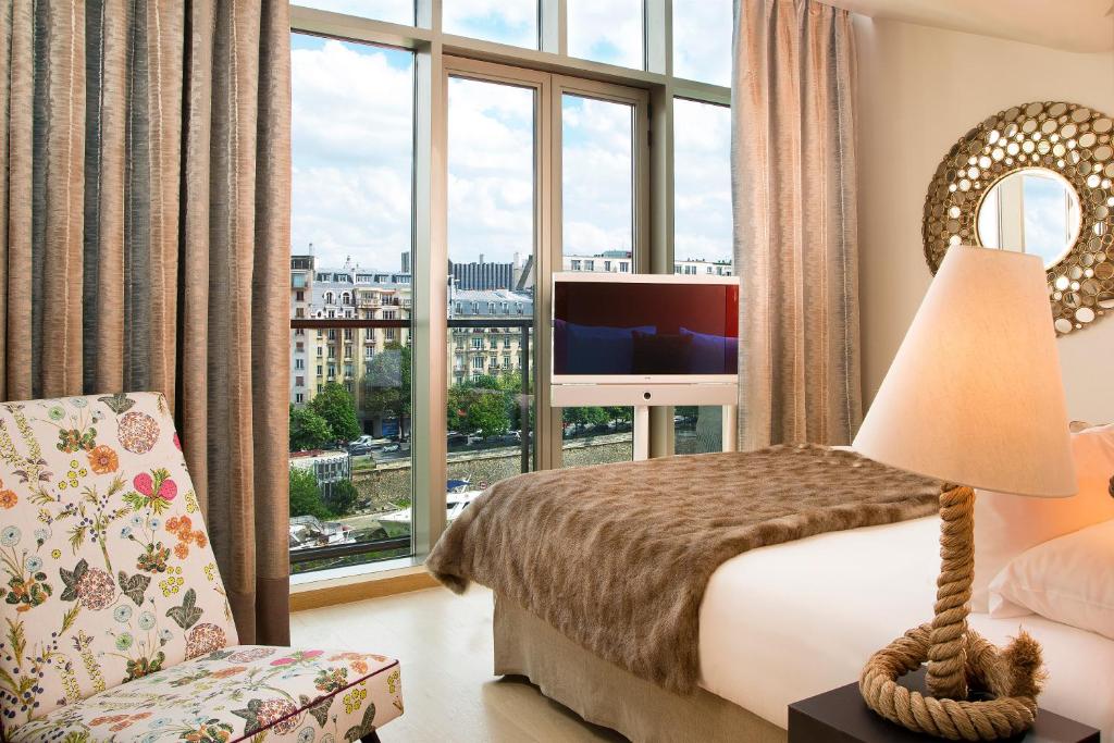 a hotel room with a bed and a large window at Goralska Résidences Paris Bastille in Paris
