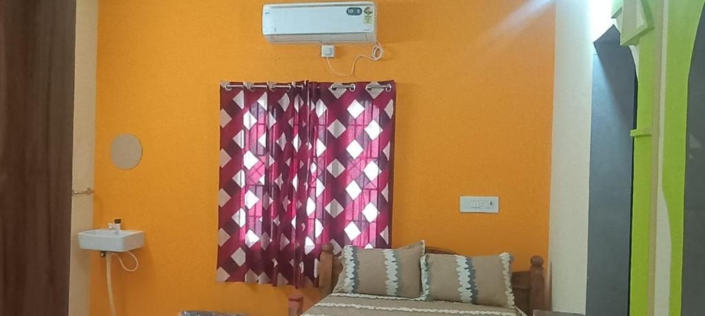 Una habitación con una pared con cortinas y un sofá. en JR Home Stay, en Tiruvannāmalai