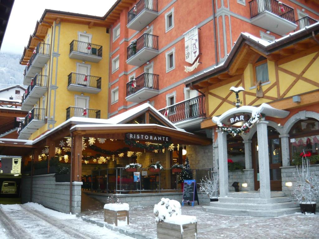 a large building with a store in the snow at Hotel Avio in Temù