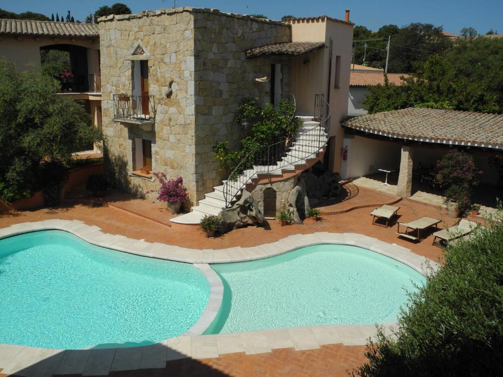 a swimming pool in front of a house at Hotel San Pantaleo in San Pantaleo