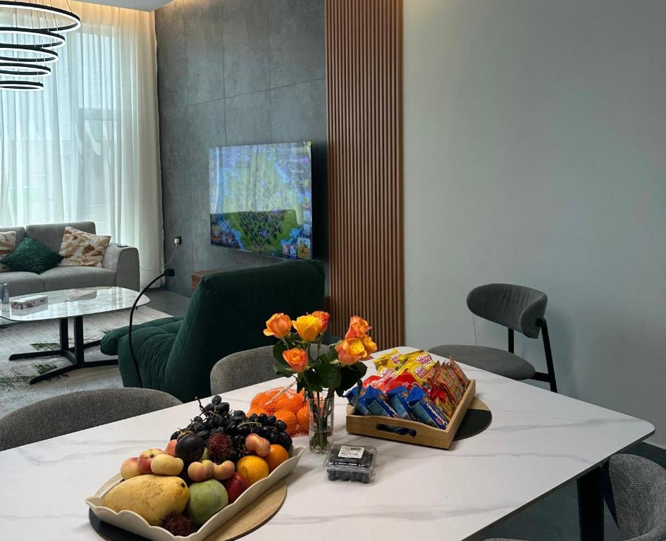 a table with a bowl of fruit and flowers on it at Altara Villa's in Ḩayl Yaman