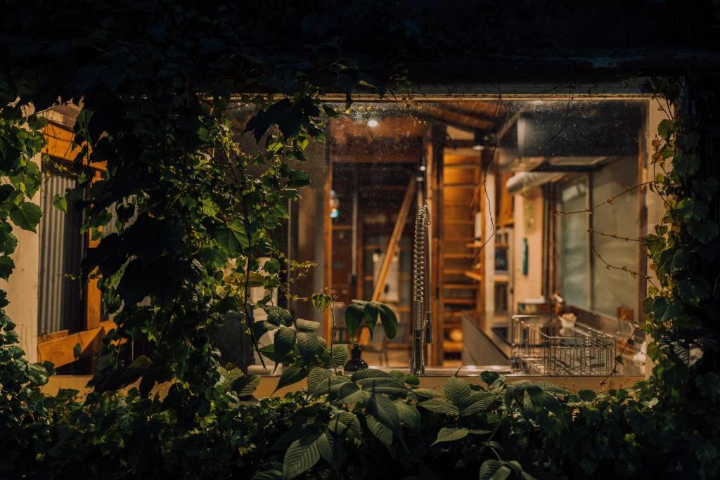 an entrance to a building at night with plants at Ivy Harajuku in Tokyo