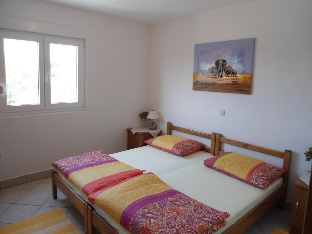 a bedroom with two beds and a window at Apartments Slavica Trogir in Trogir