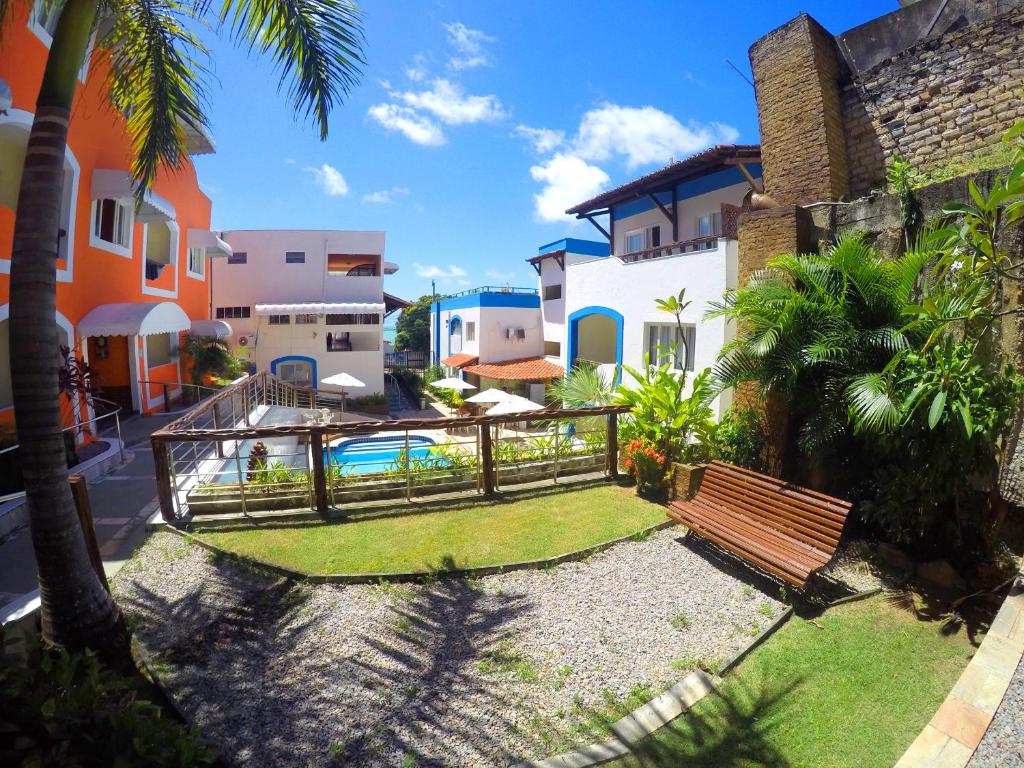 un patio con un banco y algunos edificios en Hotel Areia de Ouro, en Natal