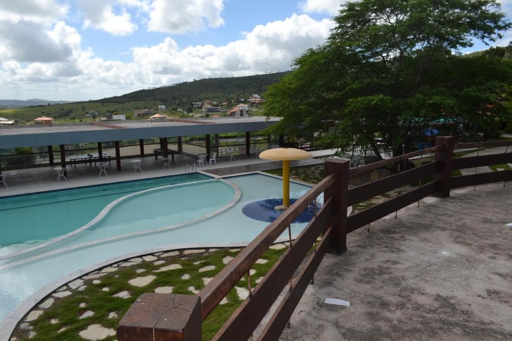 uma piscina num resort com cerca em Flat Fazenda Monte Castelo Gravatá em Gravatá