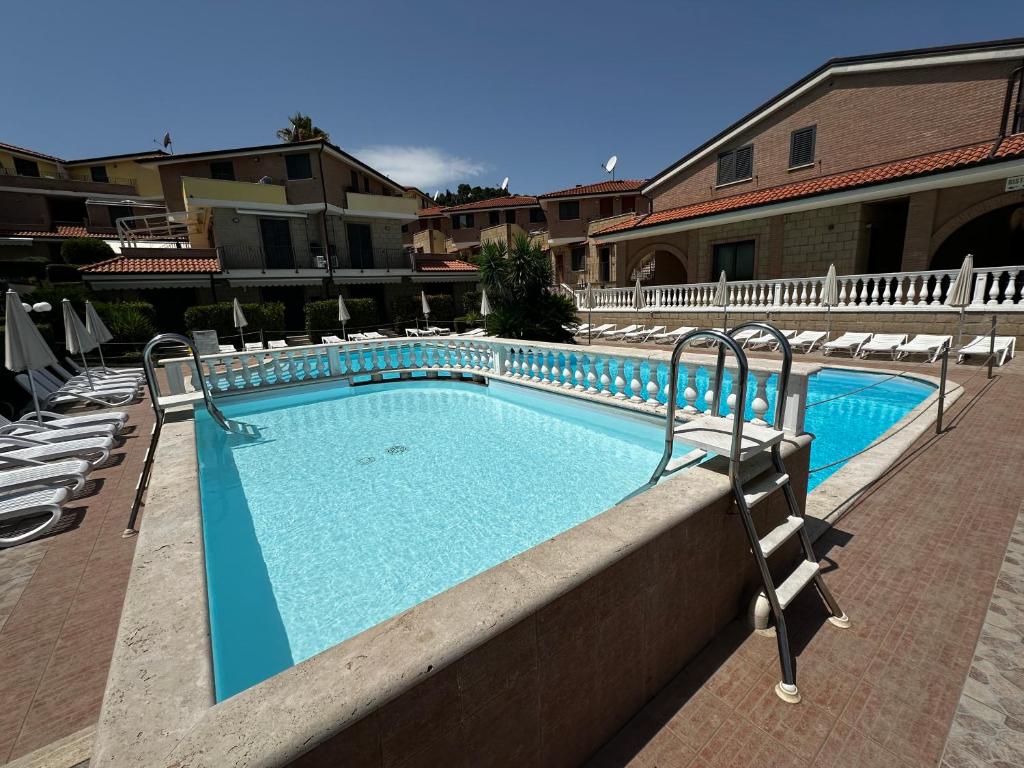 a swimming pool in a resort with chairs and a building at La Piazzetta in Tortoreto Lido