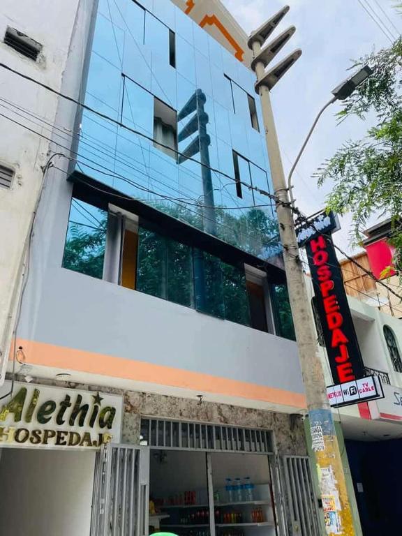a building with a sign in front of it at Hospedaje ALETHIA in Huacho