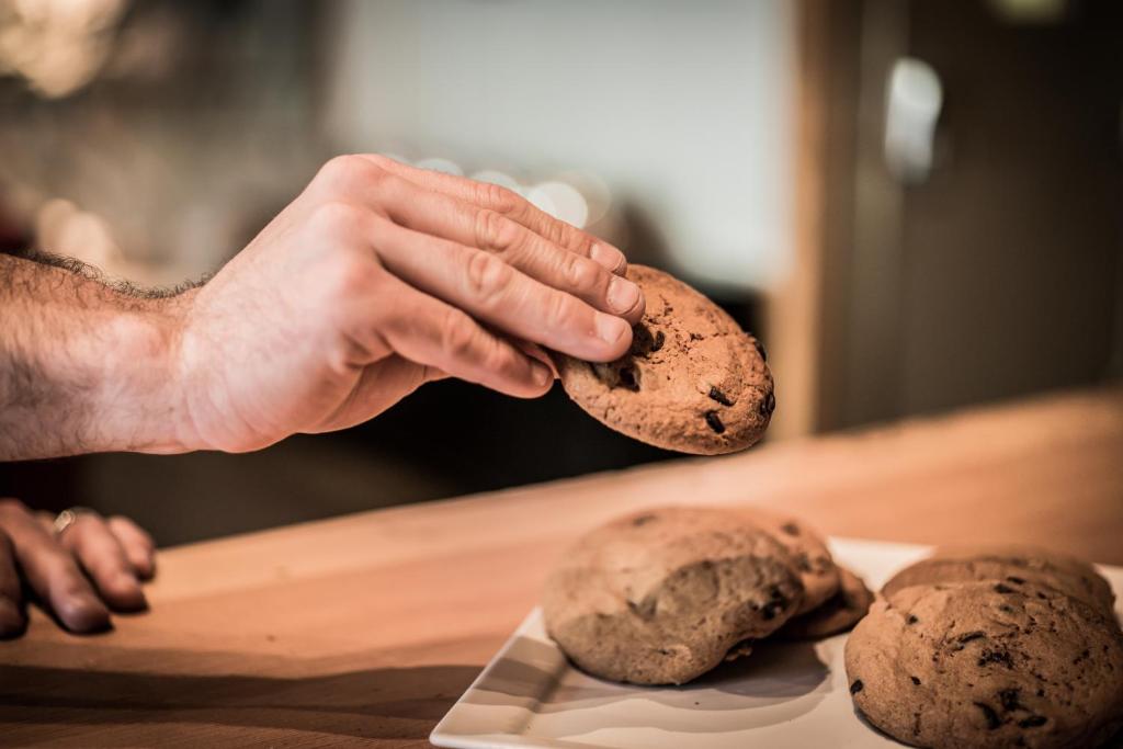 a person holding a cookie in front of two cookies at Adara Hotel in Whistler