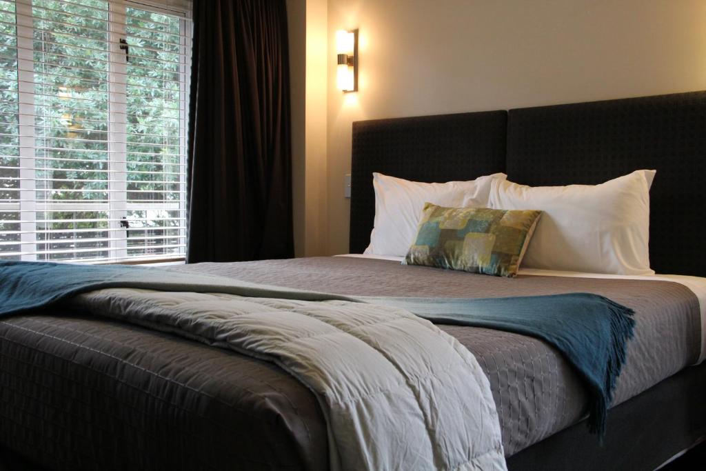 um quarto com uma cama grande com janela em Abaco on Jervois em Auckland