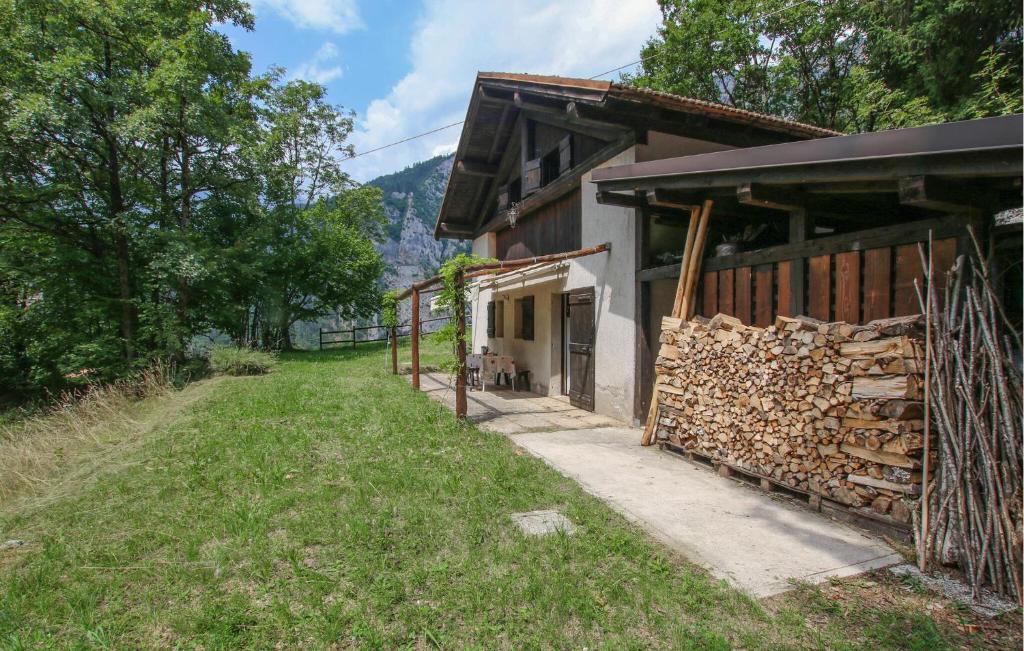 a barn with a pile of logs next to a building at Ladino House in San Lorenzo in Banale