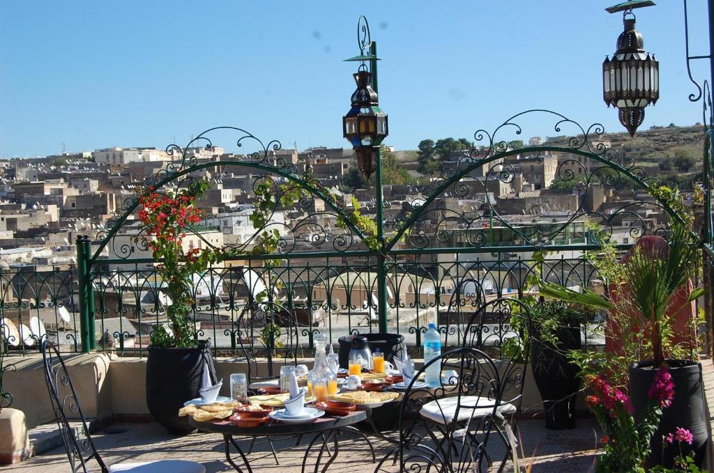 a table and chairs on a balcony with a view of a city at Riad Dar Guennoun - Luxury Suites in the Heart of Fes in Fez
