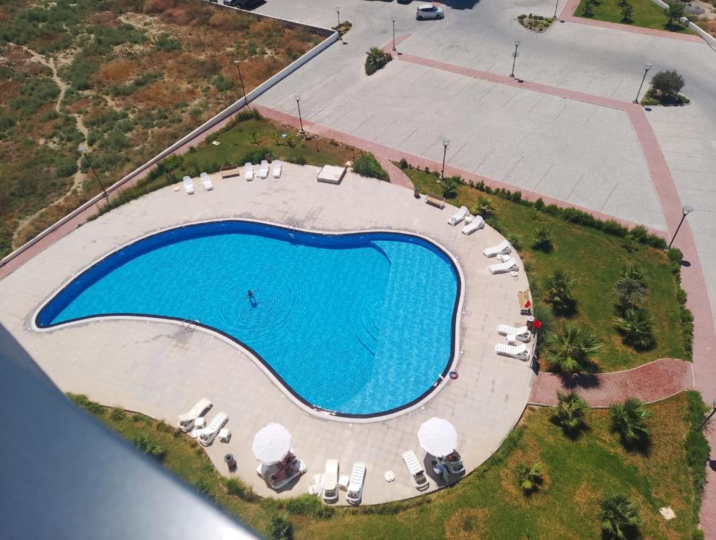 einen Blick über einen großen Pool mit Stühlen um ihn herum in der Unterkunft Sokrates in Larnaka
