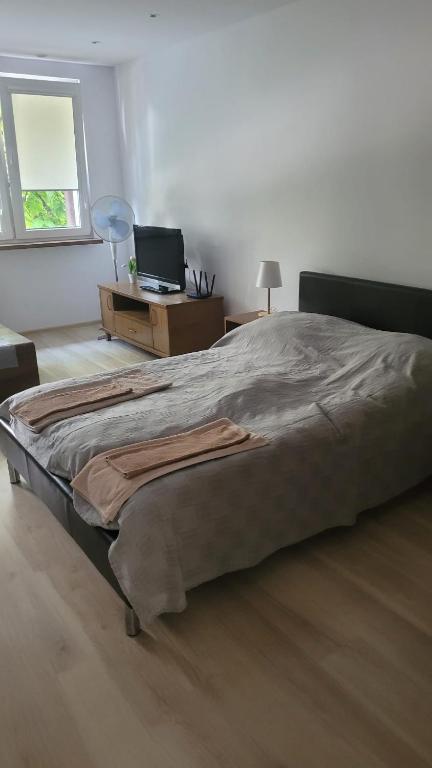 a bedroom with a large bed with a desk and a window at Mieszkanie Tarnów in Tarnów