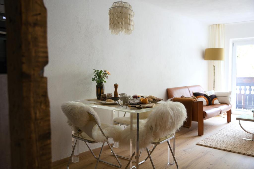 a living room with a table with fur covered chairs at Cosy & Style Zell am See in Schmitten