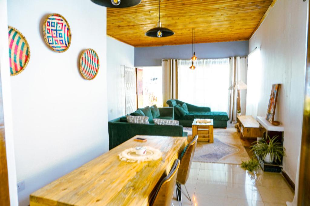 ein Wohnzimmer mit einem Holztisch und einer Couch in der Unterkunft Garden Villa 5BR Home Near Road,Nature and City Life in Arusha
