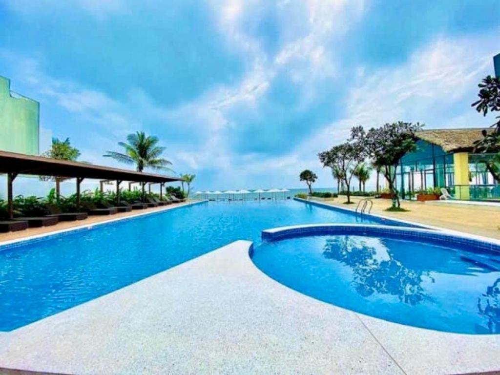 a swimming pool with blue water in a resort at Aria Vũng Tàu Resort - Căn hộ & Villa in Vung Tau