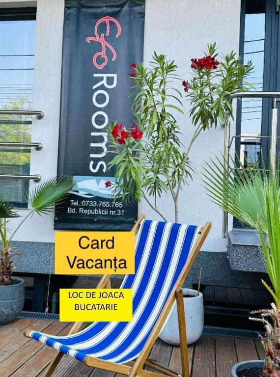 a chair on a deck with a sign on it at EfoRooms - Apartamente si Camere moderne in Eforie Nord
