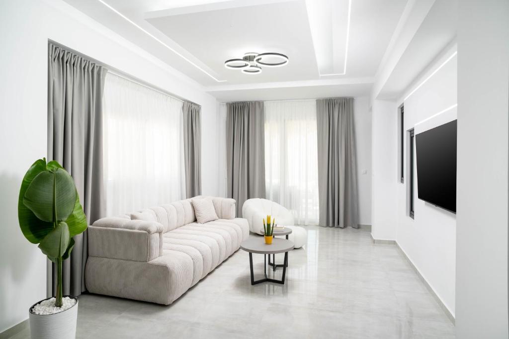 Una sala de estar blanca con un sofá y una mesa. en Lunar Dream, en Kalamaki
