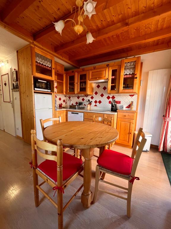 a kitchen with a wooden table and two chairs at Appartement Duplex in Habère-Poche
