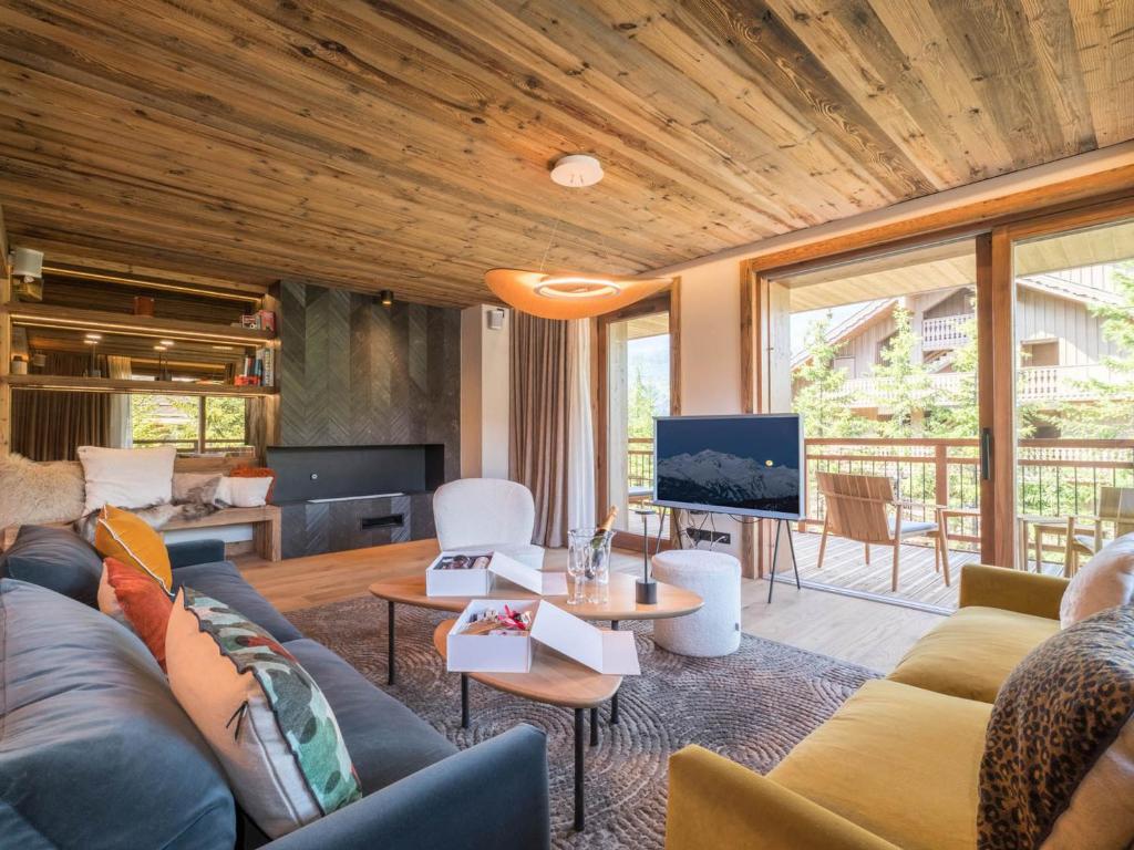 a living room with a couch and a tv at Appartement neuf 3 chambres proche des pistes, parking et Wi-Fi - FR-1-565-108 in Les Allues