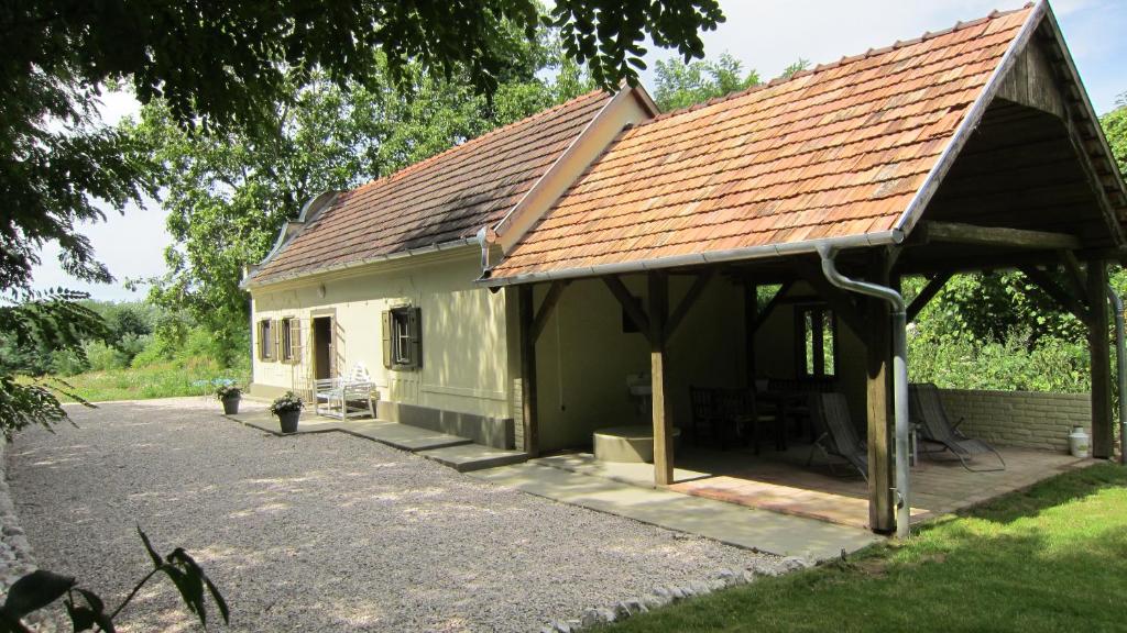 a small green house with a brown roof at Gara Cottage Private escape with modern comfort and spacious covered terrace in Garabonc