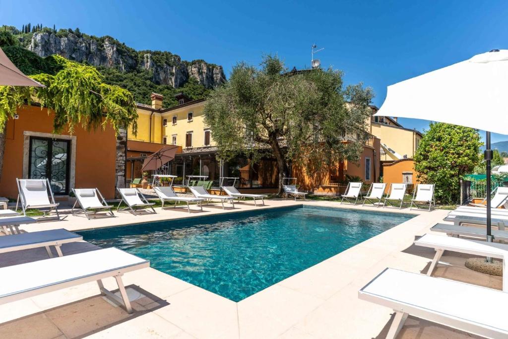 a swimming pool with lounge chairs and a resort at Corte Impero Hotel & Restaurant in Affi