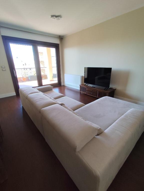 ein großes weißes Sofa in einem Zimmer mit einem TV in der Unterkunft Casa vacanze da Alice in Alghero