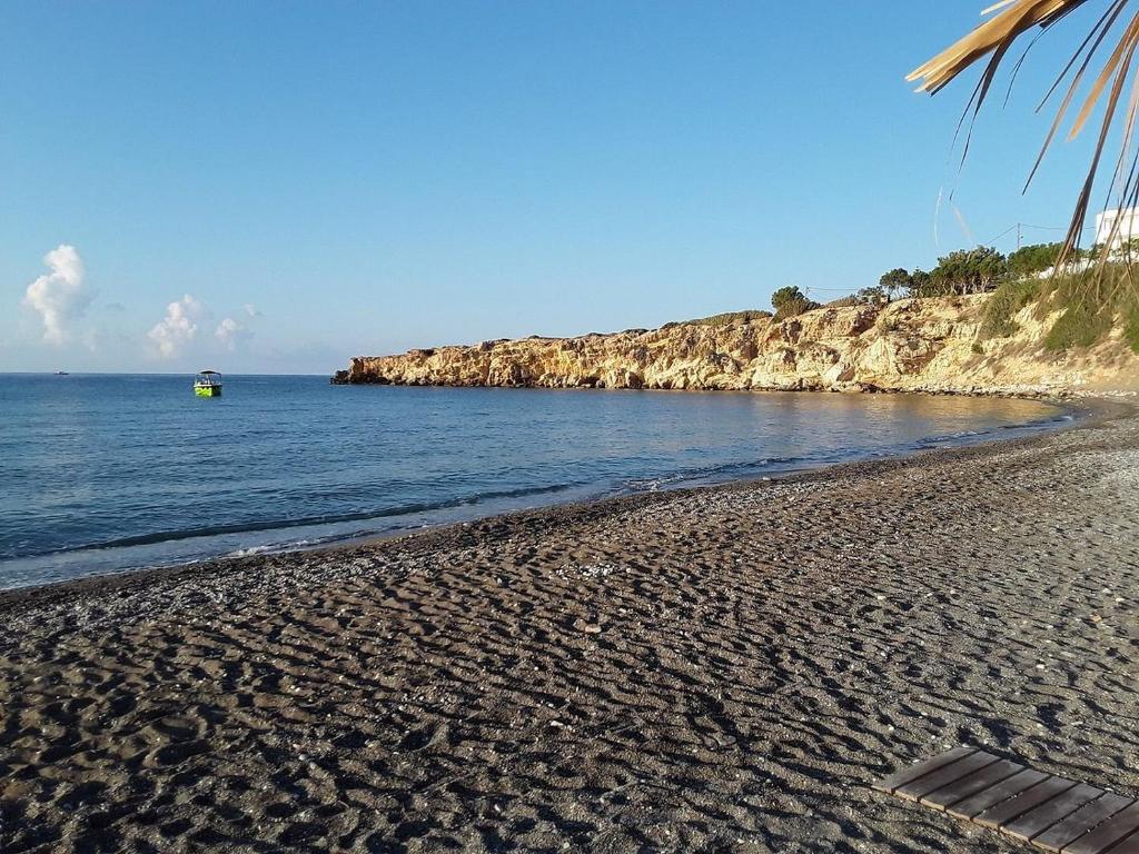 a sandy beach with a boat in the water at Avra Beach in Ferma