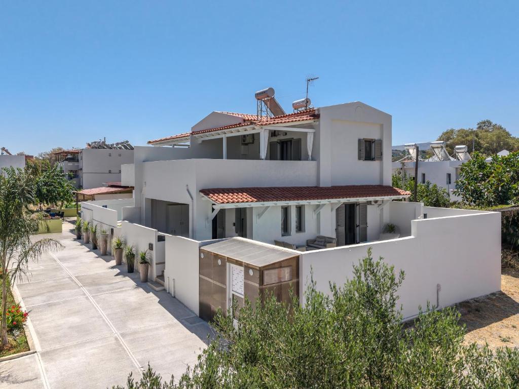 a view of a white house with a yard at Arokaria Holiday Houses in Platanes