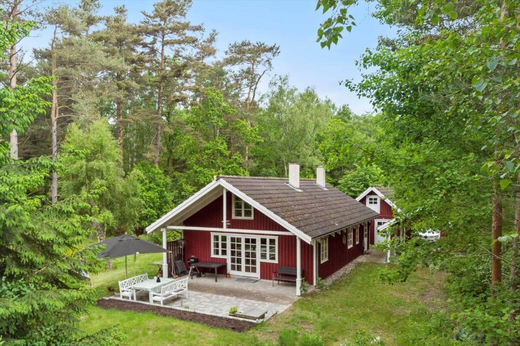 a red house in the middle of the forest at 2031-Stege-Ulvshalevej-301 in Stege