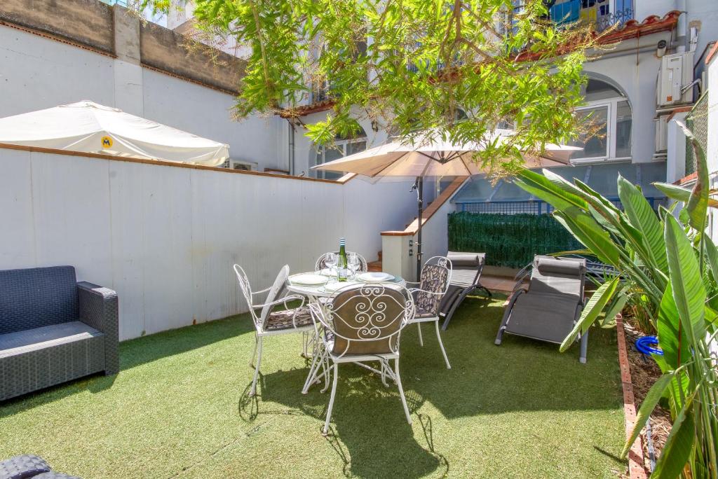 un patio avec une table, des chaises et un parasol dans l'établissement Garbi 1-2 - Barneda Premium, à Roses