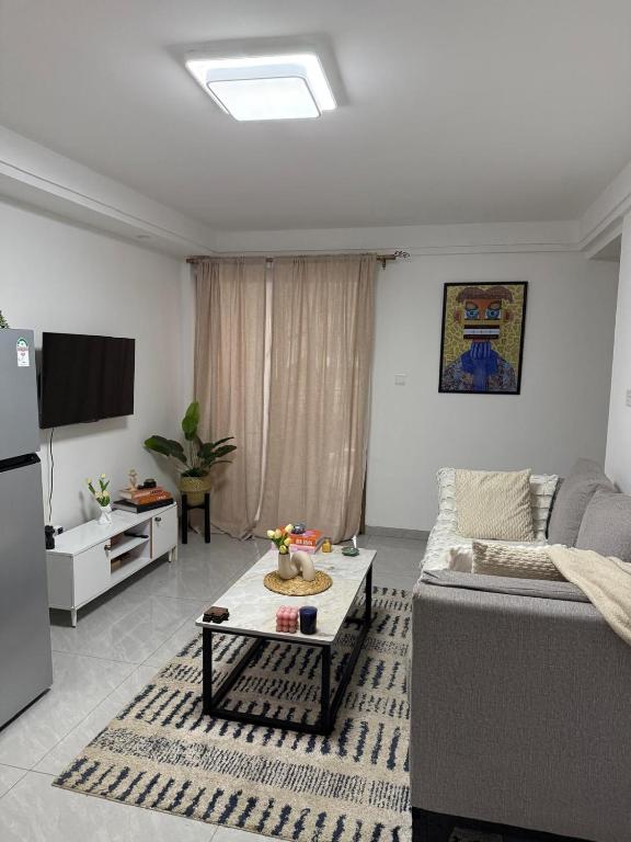 a living room with a couch and a table at Modern 1 bedroom in the middle of Kilimani in Nairobi