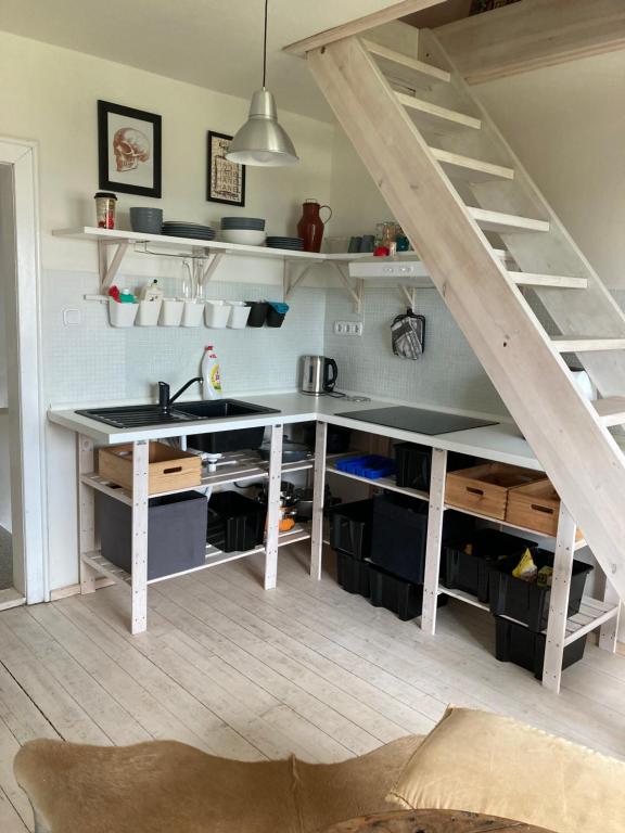 a kitchen with a sink and a staircase with shelves at Apartmán pod lesem in Hazlov
