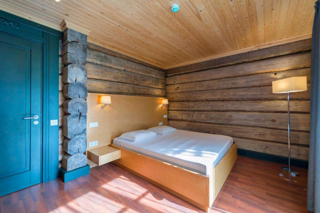 a bedroom with a bed in a room with wooden walls at Rakaru brīvdienu māja in Salacgrīva