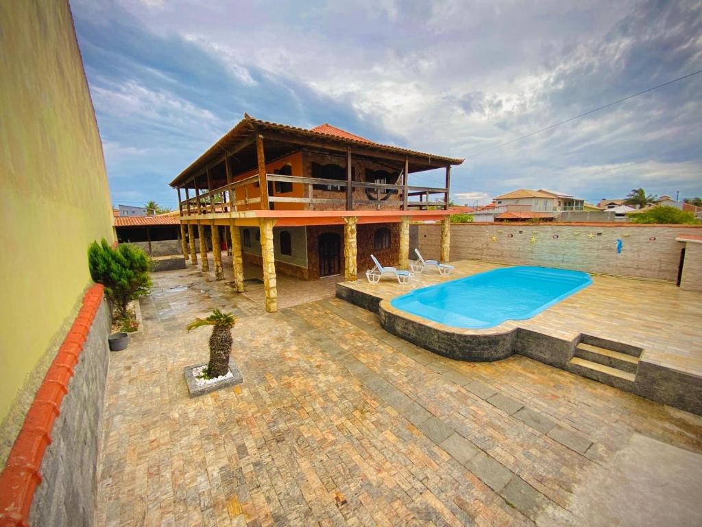 a house with a swimming pool on a patio at Casa Top Arraial - Grupos e Famílias - 20 pessoas - 400 metros da praia in Arraial do Cabo