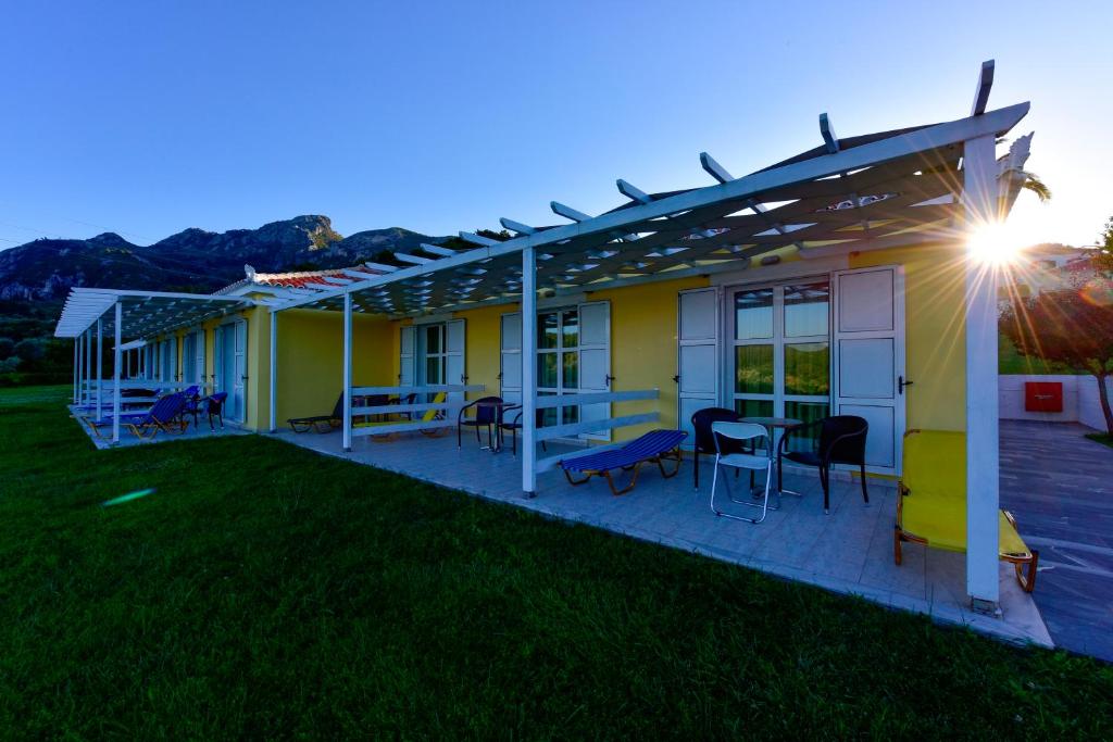 a house with a deck with a table and chairs at Arion Hotel in Kokkari