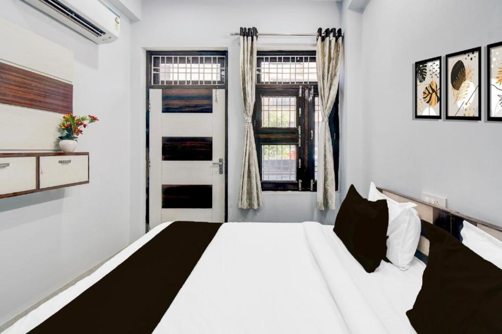 a white bedroom with a white bed and a window at Hotel Sanwariya in Jaipur