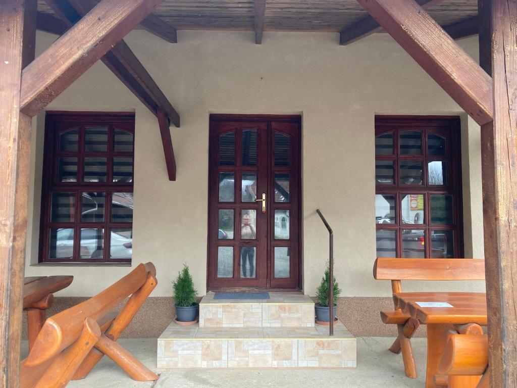 a house with three windows and a wooden bench at Gesztenyés Apartman Mátra Wellness in Parád